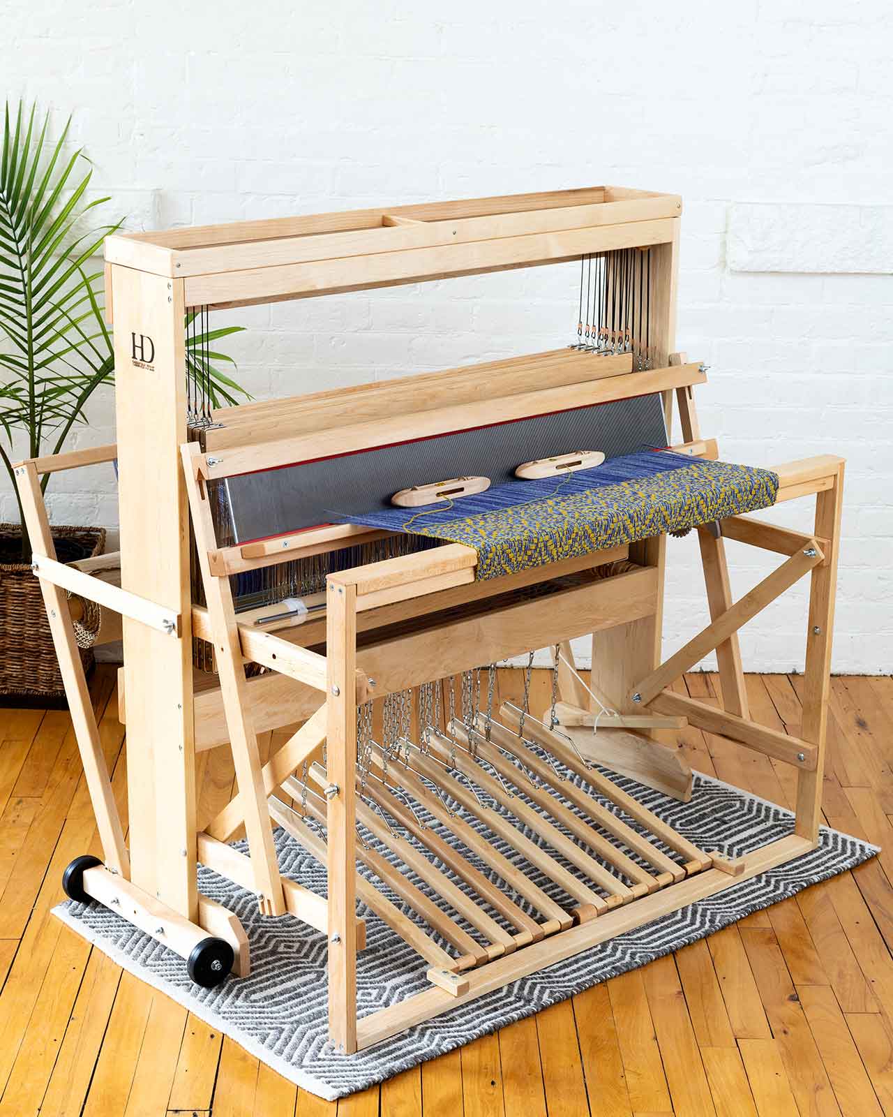 Floor loom with blue and yellow weaving project