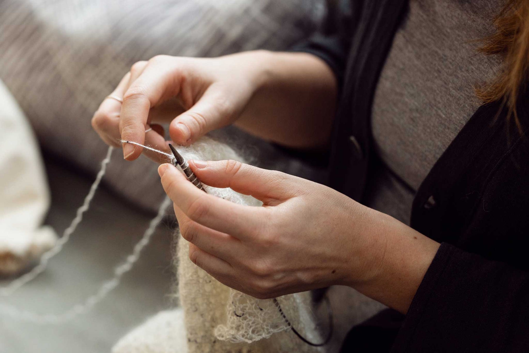 Person knitting with white yarn