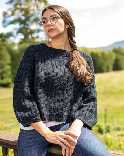 Woman outdoors wearing a loose black sweater